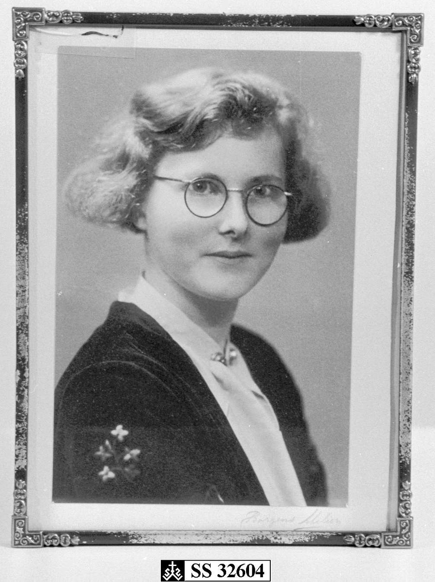 Bildet viser en pike med briller og kort hår.