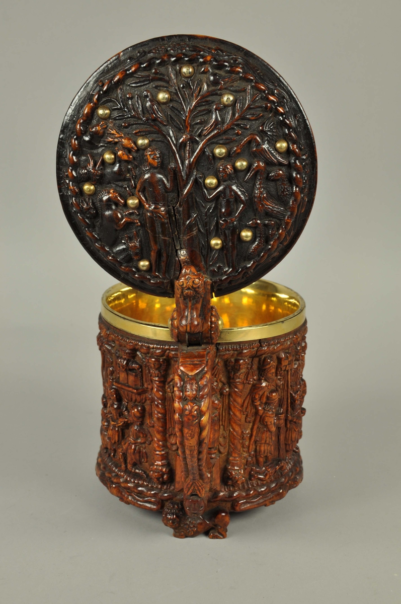 Ølkanne av valbjørk, innvendig foret med forgylt sølv i korpus og lokk. Kannen er skåret ut med scener i dypt relieff, nærmest rundskulptur på sidene, og med flatere relieff og enklere skurd på lokket. 
På lokket er det en framstilling av Syndefallet, med Adam og Eva stående under kunnskapens tre der de strekker seg etter epler, mens slangen snor seg om treets stamme og andre dyr og fugler står rundt omkring. Adam og Eva er nakne, men holder en gren foran skjødet, som om de allerede har spist av eplet. Rundt omkring i dette feltet er det satt inn forgylte nagler. Billedfeltet er omrammet av en tausnoingsbord og utenfor denne en blomsterranke.
Lokket har også en lokknapp som jekk mot håndtaket, formet som en løve. Håndtaket er formet som en slange i underkant, og som en slange med menneskehode på oversiden, eventuelt kan dette tolkes som en havfrue, siden halen ender i en spord.
Kannen har utskårne motiver rundt hele korpus, delt inn i felter med tausnoingsornamenter øverst og nederst og med snodde søyler mellom scenene. Søylene har base og kapitel formet som løvehoder. Det er tre bein formet som liggende kronede løver, og i feltene mellom er det to krokodiller vendt mot hverandre. 
Under håndtaket er det skåret en scene med en mann og en kvinne som står under en baldakin. Kvinnen holder en blomst i den ene hånden, mens mannen holder hennes andre hånd, altså et trolovelse- eller bryllupsbilde. 
Neste scene er Moses, med strålene ut fra pannen, som slår vann av klippen, mens andre mennesker står omkring, neon samler vann i forskjellige kar og bærer bort og en ung mann har lagt seg ned og drikker fra vannstrømmen.
Neste scene viser Moses stående med lovens tavler. Han har stråler fra pannen, og er plassert i en nisje.
Neste scene er Kongenes tilbedelse, der Maria sitter med Jesubarnet på fanget, mens Josef står bakenfor og lener seg på tømmermannsøksen. Foran dem er de hellige tre konger som bærer gaver til barnet, to står og en kneler.
Neste scene er Aron, Moses bror, som var den første yppersteprest. Han er kledd i yppersteprestens drakt slik den er beskrevet i Bibelen med bjeller og granatepler, mens han holder et røkelseskar. han er som Moses plassert i en nisje.
Siste scene er Isaks frierferd, der Abrahams tjener er sendt ut for å finne en kone til Isak. Rebekka har hentet vann fra brønnen, som er framstilt bak i scenen som en fontene der vann strømmer ut gjennom fire løvehoder. Tjeneren får drikke av hennes urne, mens en annen pike sitter med et kar og en tjener står og passer flere kameler i bakgrunnen.
Under kannen er det en skrue og mutter som fester sølvforingen til trekannen. En innskrift er grovt skåret inn, men er vanskelig tydbar, men synes å være tre bokstaver, hvorav de første synes å være O ug T eller I. Lokket er foret, og med en gravert innskrift på innsiden, sammen med kongemonogrammet C7.