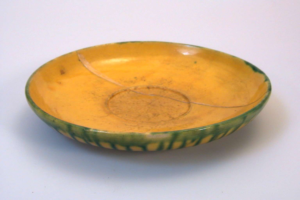 Skål i gul keramikk med grønn dekor. Brukskunst.