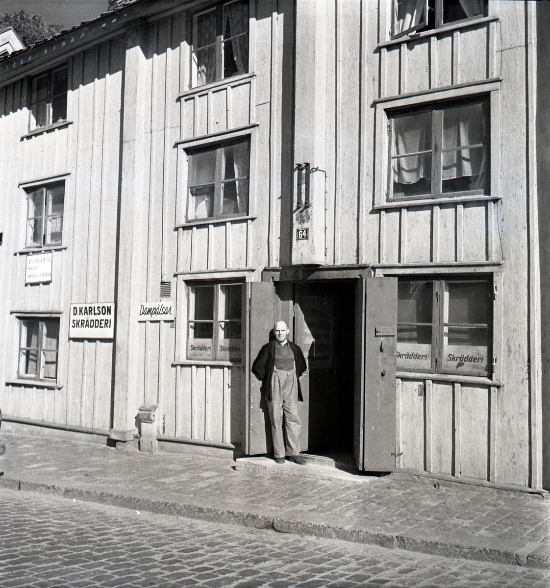 Skräddarmästare Johansson står vid sin affär på Borggården vid Pilens backe.

Kopparslagaregården: Huset flyttades till Gamla Linköping från Storgatan 64. Senast 1754 stod byggnaden färdig, då öppnades nämligen kryddkramhandel i gården. I mitten av 1750-talet lades gränden mellan Järntorget (Kryddbodtorget) och S:t Korsgatan (Rådmansgatan) ut över Lönnbergs tomt. Då blev gårdens portlider infart till gränden. Gathusets tredje våning byggdes på av handlare Pihl vid mitten av 1810-talet.