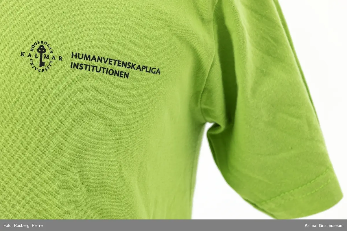 KLM 46520. T-shirt. Ljusgrön bomullströja i storlek S med tryck på bröstet: Högskolan i Kalmar University, Humanvetenskapliga Institutionen.