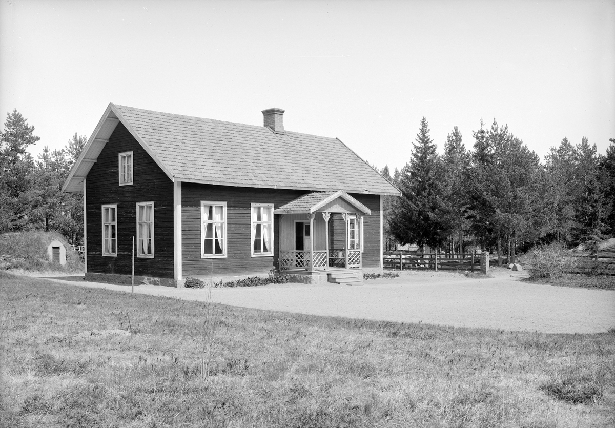 Lidens skola i Västra Harg. Skolhuset som uppfördes 1903 inrymde sin litenhet till trots lärosal och lärarbostad om 2 rum och kök. Vid tiden för bilden, 1925, drevs skolan av lärarinnan Anna Isaksson, som även disponerade bostaden. Upplysningsvis brann skolhuset ned till grunden 1963.