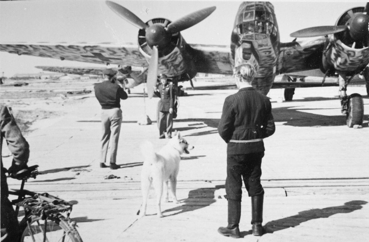 Da de norske politistyrkene og den allierte transportavdelingen ankom Bodø den 13. mai, befant det seg fortsatt en større mengde tyske militærfly på flyplassen. En offiser tar bilde av en annen foran en Junkers  Ju 88, med lokalbefolkningen som tilskuere.