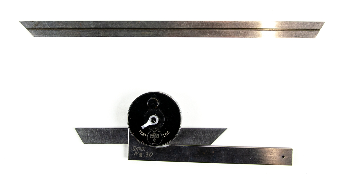 Optisk vinkel nr. 30
Optisk vinkel i metall som förvaras i original svart trälåda tillverkad av Carl Zeiss Jena. På insidan av locket sitter brukanvisningar på tyska. Verktyget består av en avrundad svart del med fast och lös läge och två avlånga metallblad. En till längre metallblad ingår också i lådan och sitter lös.
