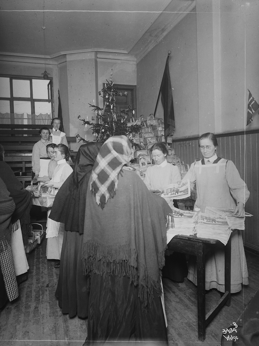 Frelsesarméen sørger for utdeling av sponkurver med mat og gaver til eldre kvinner i forbindelse med jul. Fotografert 1911.