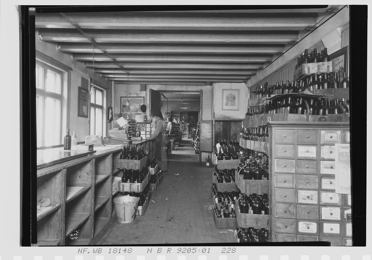 Lager fylt med vinflasker som står i kasser, Vinmonopolet. Fotografert 1924.