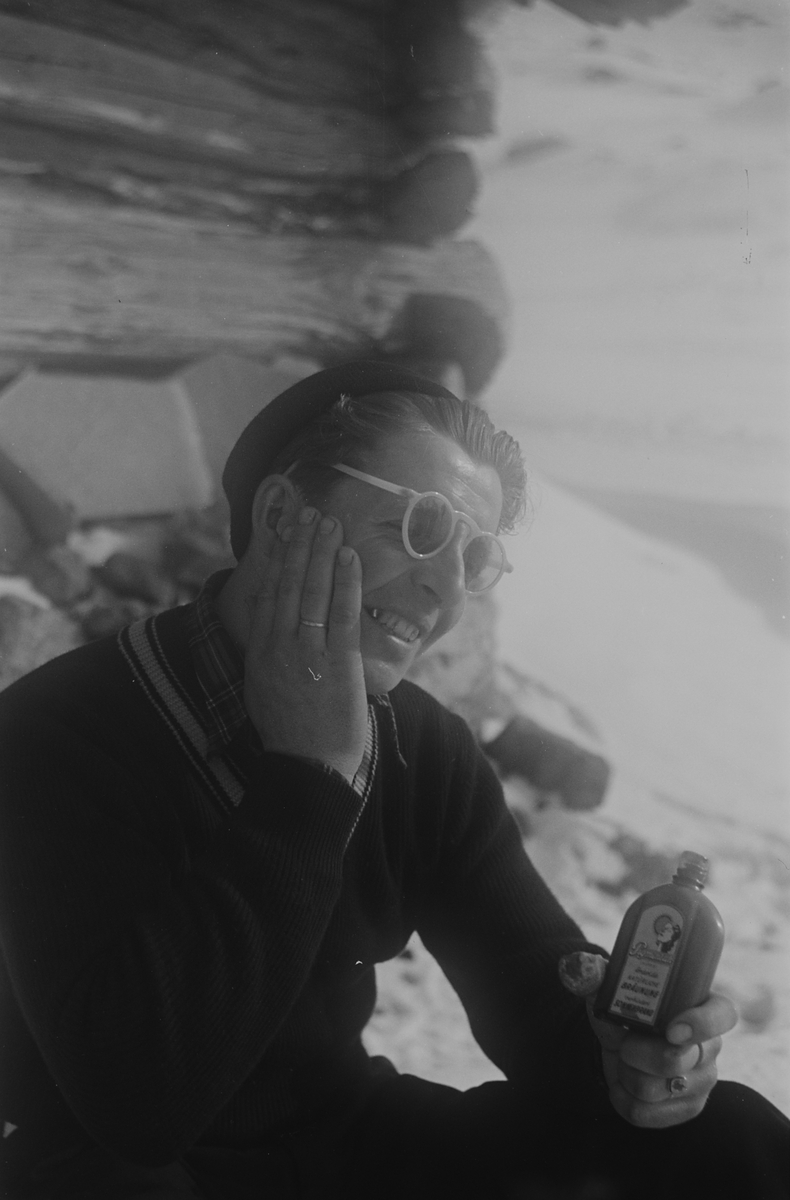 Mannlig påsketurist smører seg med solkrem. Fotografert 1940.