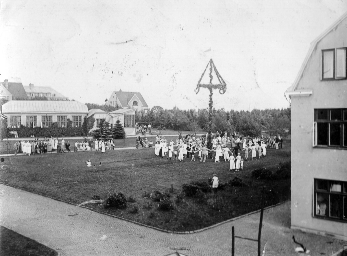 Midsommarfest på Kustsanatoriet Apelviken 1942. Ringlekar kring midsommarstången med personal och patienter.
