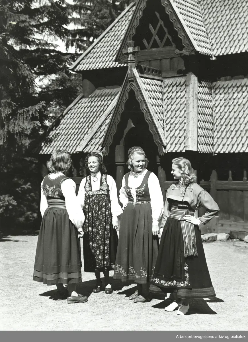 Fire kvinner i bunad. Antatt Gol stavkirke på Norsk Folkemuseum. Udatert