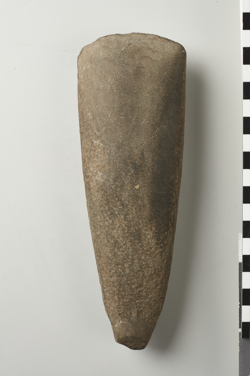 Kile af Sten, 19 cm. lang, Form som NO. 6, men tyndere, sleben fra Eggen langt op paa Bredsiderne, desuden ogsaa lidt ved Banen. 10305. 221.