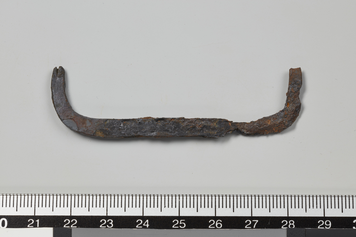 Treforbinder av jern. U-formet, med avrundede endestykker. L. 6,9 cm. H. 1,8 cm. T. 0,3 cm.