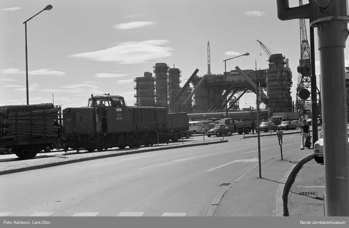 Diesellokomotiv Di 2 846 med godstog på Rådhusplassen på Havnebanen i Oslo. I bakgrunnen oljeboringsplattform under bygging