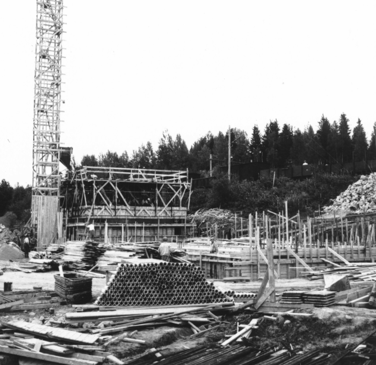 Ni bilde av forskalingar og forskalingsarbeid under bygginga av Bø mølle i 1952-53. 