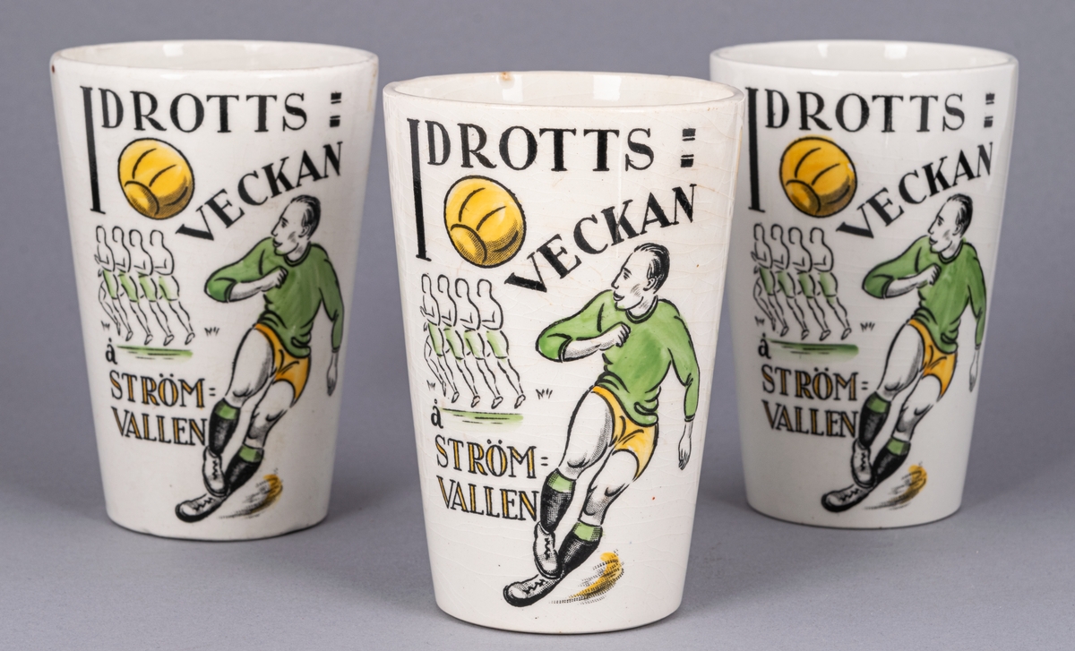 Bägare, 3 st, flintgods. Glaserad. Vit med idrottsmotiv i svart, grönt och gult. Text: "IDROTTSVECKAN Å STRÖMVALLEN 5-12 SEPT. 1926".