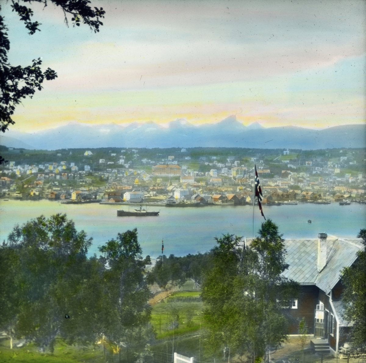 Håndkolorert dias. Utsyn over Tromsø by. Passasjerskipet "Stavangerfjord" sees i Tromsøysundet. 