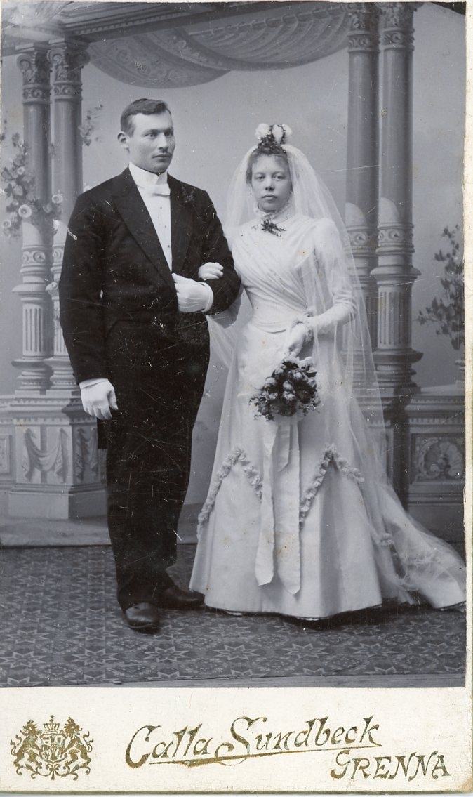 Kabinettsfotografi av ett brudpar, bruden i vitt.