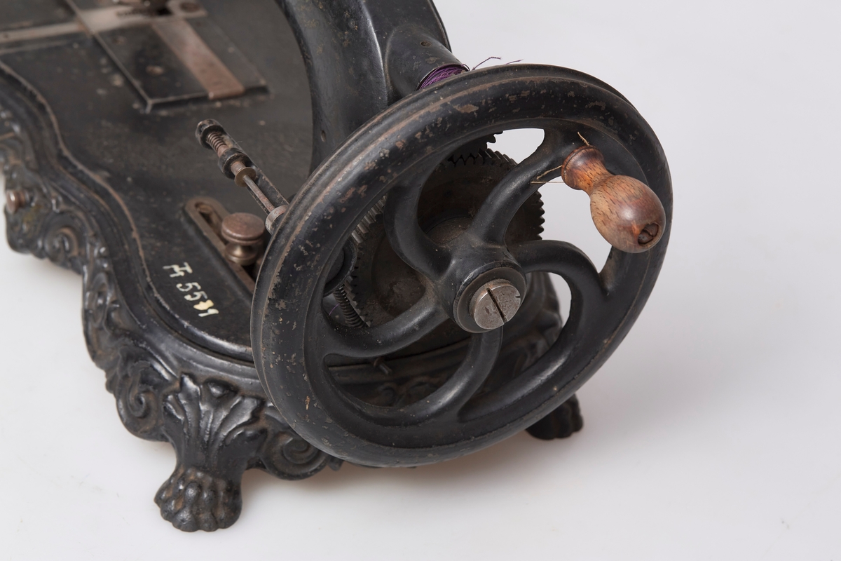 Hjulet forsynt med trehåndtak, åpen kamhjuloverføring fra svinghjulet til maskinen. Spolen går i maskinens lengderetning, spolerokk. Til maskinen hører en låsferdig, brunmalt kasse