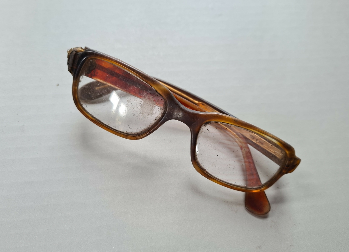 Briller med firkantede glass og brun innfatning.