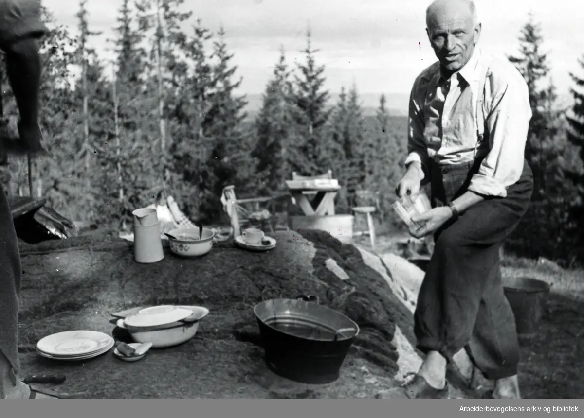 Martin Tranmæl tar oppvasken på hytta i Bærum, 1947.