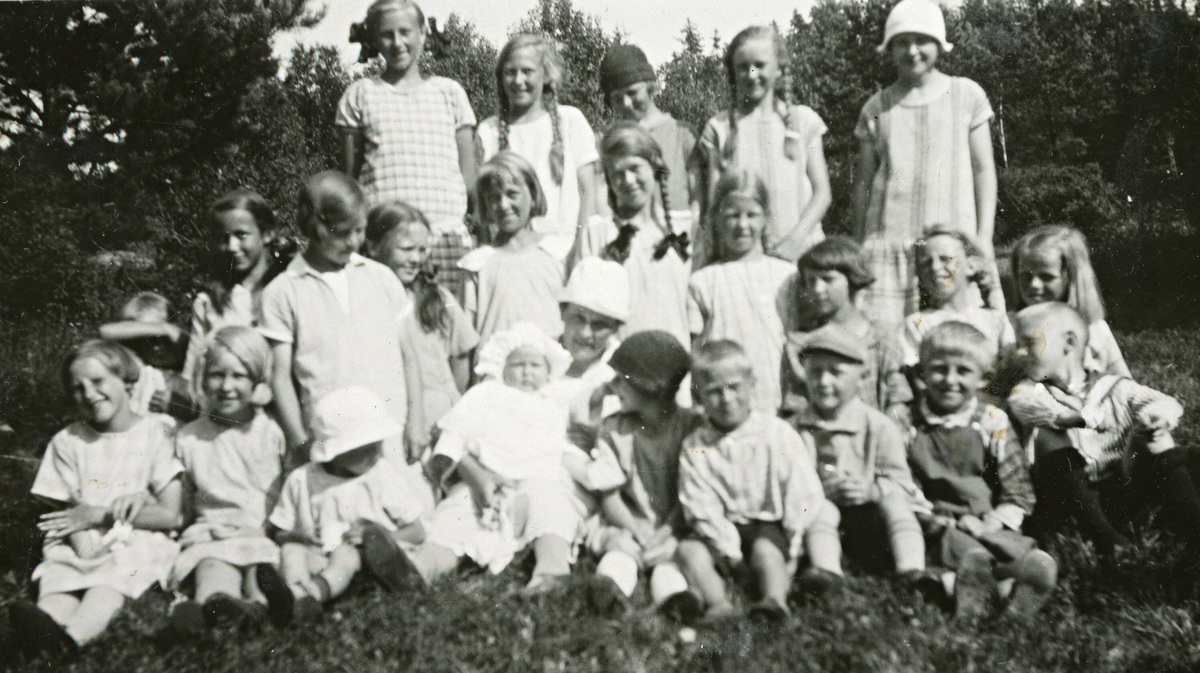 Astrid Margrethe Terjesen med dotter Tordis og ei rekkje jenter rundt.  Tatt 26.7.1926