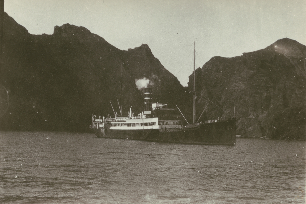 Fotografi från Albin Ahrenbergs resa till Grönland 1929. Motiv av båt och berg vid Västmannaöarna, Island.