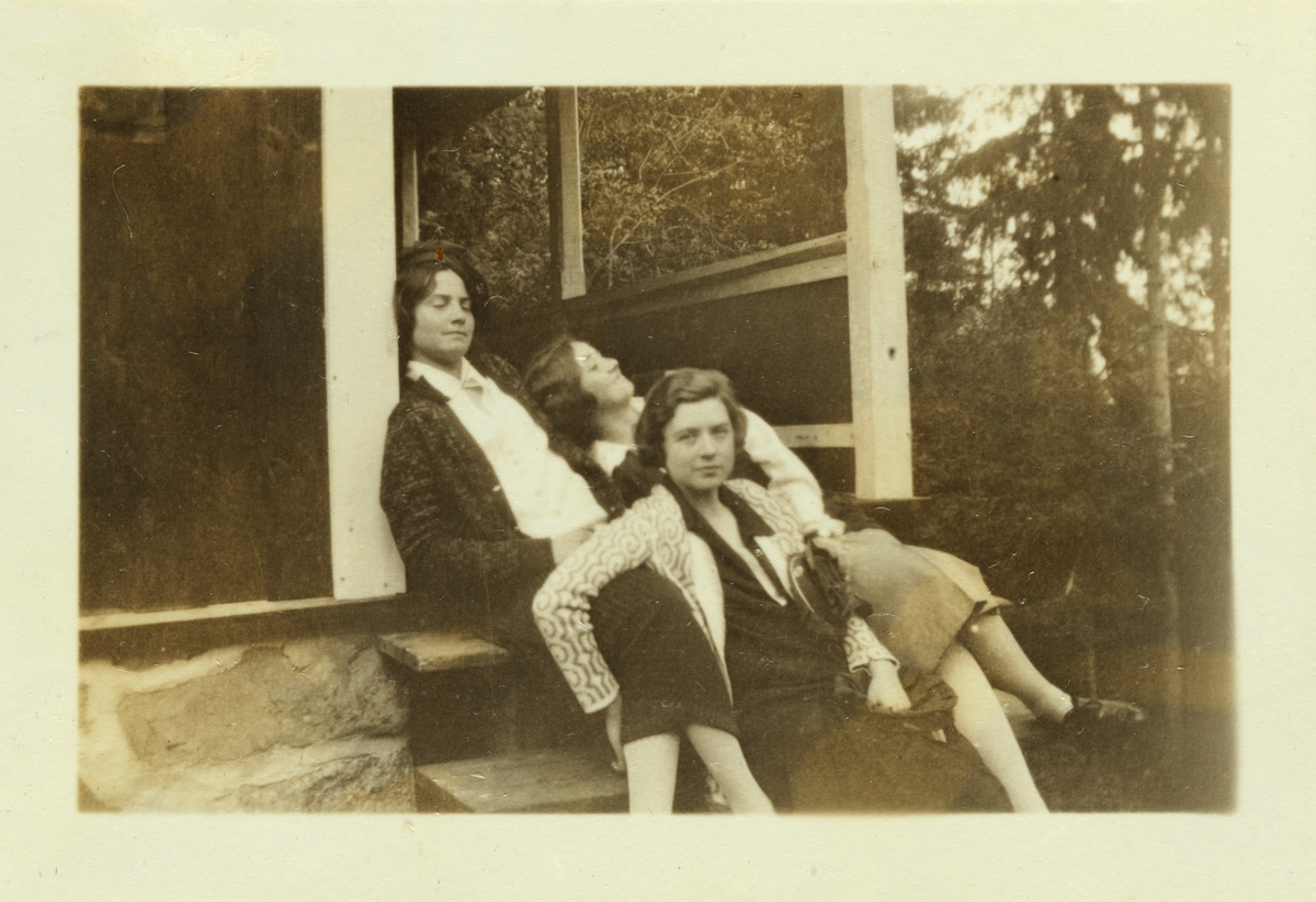 Lucy Egeberg, Cecilie Broch og Sisken Skjelderup hviler ut på hyttetrappe, muligens i Bærum. Fotografert mai 1926.