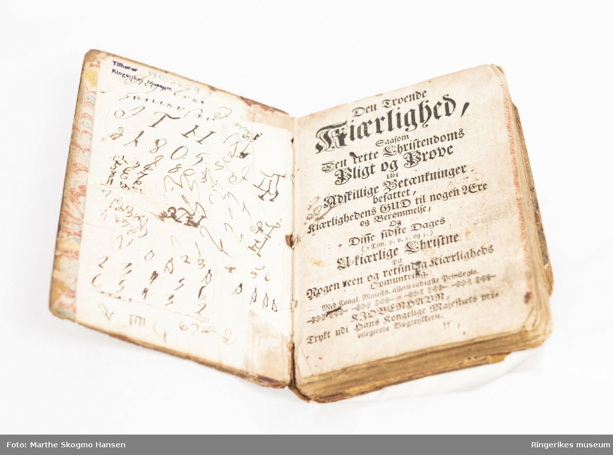 Den troende Kiærlighed. Trykket i københavn i 1702. Liten bok med 143 sider. Skriblerier på innsiden av begge permer. Trepermer dekorert med mønstret papir.