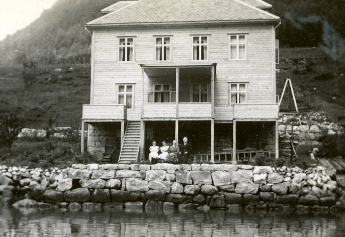 Eit hus ved ein fjord.  Foto tatt frå to ulike posisjonar.
