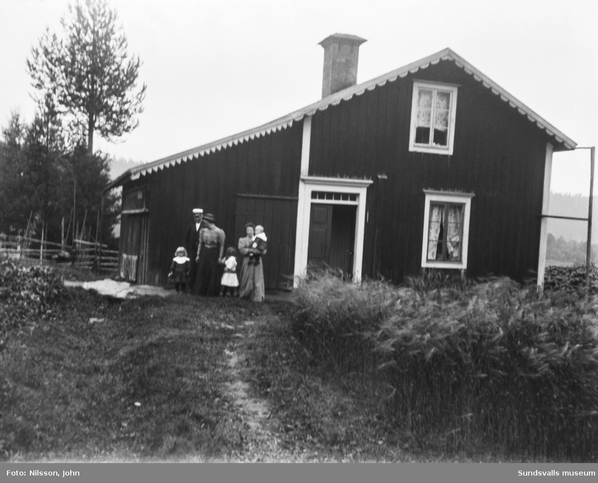 Två bilder med en man, två kvinnor och tre små barn framför gaveln på ett bostadshus med snickarglädje.