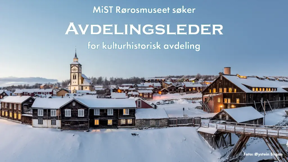 Dette er et panoramabilde av Røros med Rørosmuseets bygninger i front, og Røros kirke og hus i bakgrunne. Det er et vintermotiv med mye snø og blå himmel. Over bildet står teksten: "MiST Rørosmuseet søker avdelingsleder for kulturhistorisk avdeling.