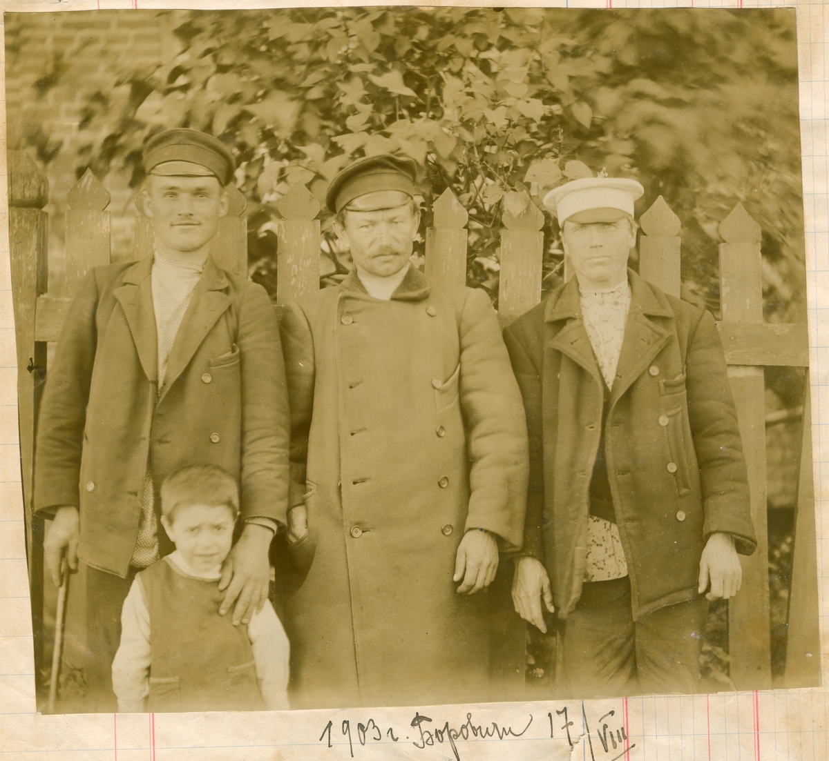 Gruppebilde av tre menn og et barn. Borovichi 1903. Gutten er Nikolaj Rostin, sammen med tre uidentifiserte menn.