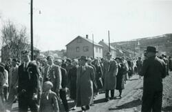Folk går i tog i Storgata i Kirkenes 17. mai 1956. Rektor Ax