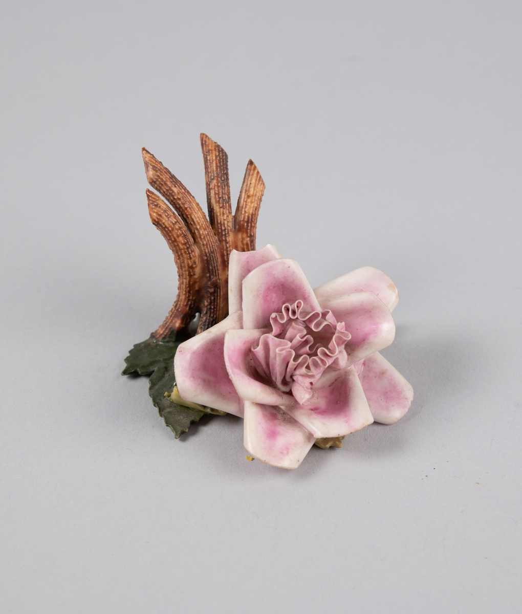 Modellert rose til borddekor. Stilk og grener bak danner en holder til kort eller serviett.
