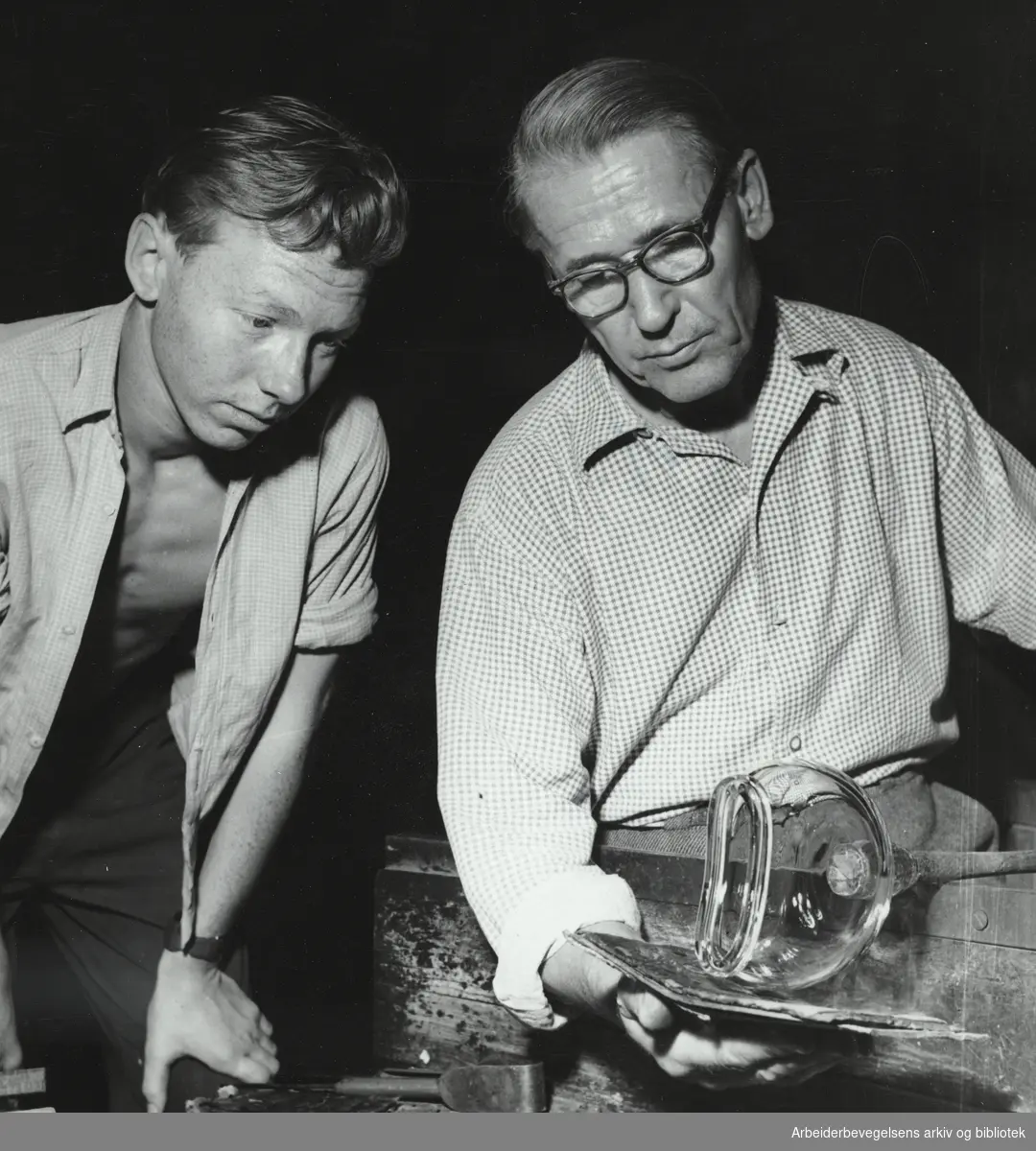 "Vi besøker et glassverk". Wilhelm Johansson former en vase mens læregutt Ivar Nordlie ser på. Billedreportasje fra Hadeland Glassverk i Magasinet for Alle, november 1955.