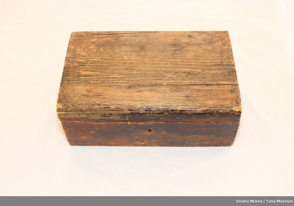 Brunlakkert kiste i tre med lås, nøkkel mangler. Innvendig lokk, tynn treplate er knekt.