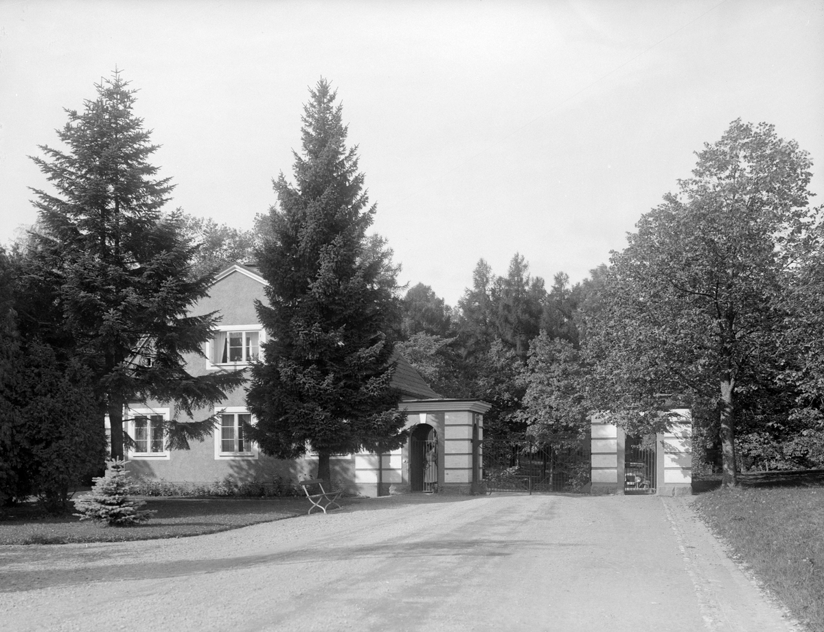 Vy mot den vid tiden relativt nya entrén till lasarettsområdet i Linköping. Byggnaden är den så kallade portvaktsstugan varifrån grindarna kunde regleras. Anläggningen uppfördes 1922-23 efter ritningar av Axel Brunskog.