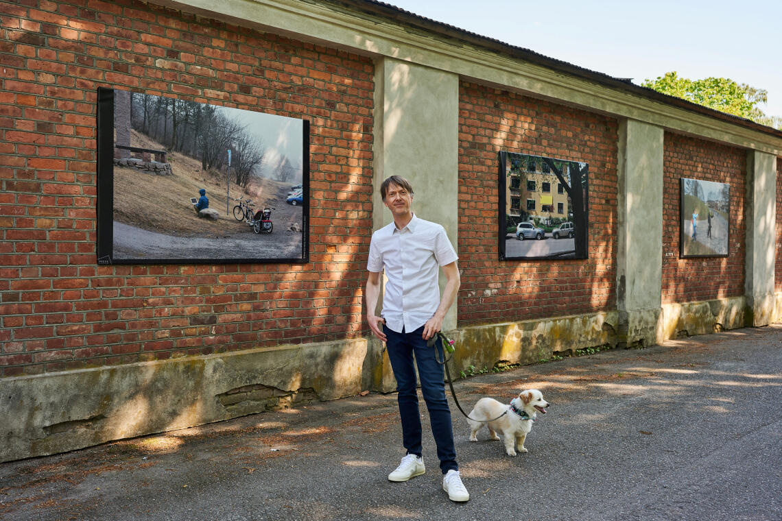 Knut Egil Wang avbildet foran utstillingsveggen med hunden sin.