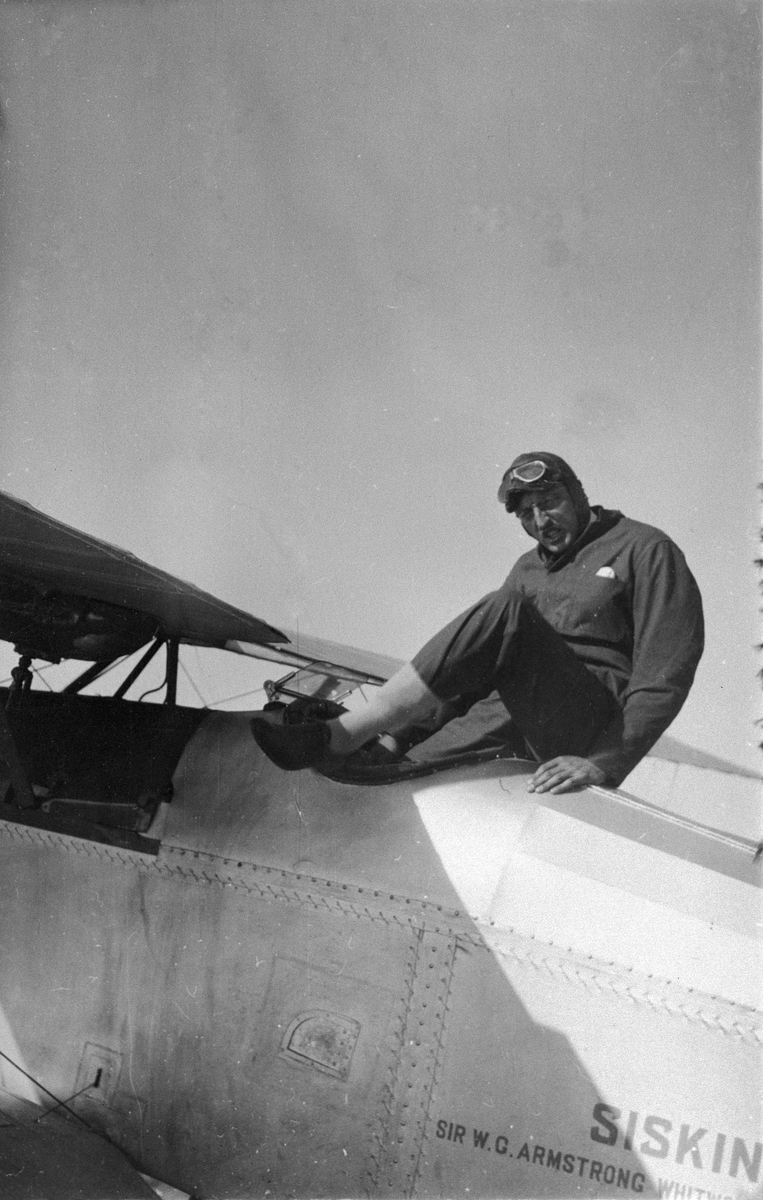 Flygförare Frank Courtney klättrar ur flygplan Armstrong Whitworth Siskin på Internationella luftfartsutställningen i Göteborg, ILUG 1923.
