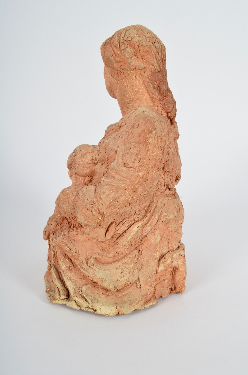 Terrakottafigur som visar ei stjande kvinne med eit born. Motiv frå teikning av Michelangelo eller Rafael.