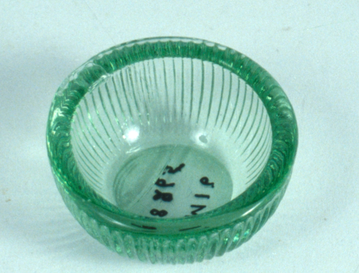Runt i grönt pressglas.
Fasettslipad dekor.

Neg.nr. 1987-04