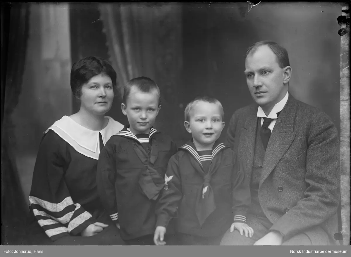 Familien Coward, kvinne og mann med to gutter fotografert i studio.