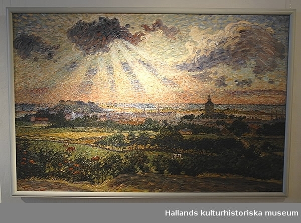 Oljemålning av Nils Kreuger. "En kuststad." (Varberg.) 1909 Bildmått: 91 x 140 cm.Motivet är Varberg sett från Håstensberget-fästningen, stadshuset med dess torn, kyrkan och hamnen syns med havet som bakgrund.