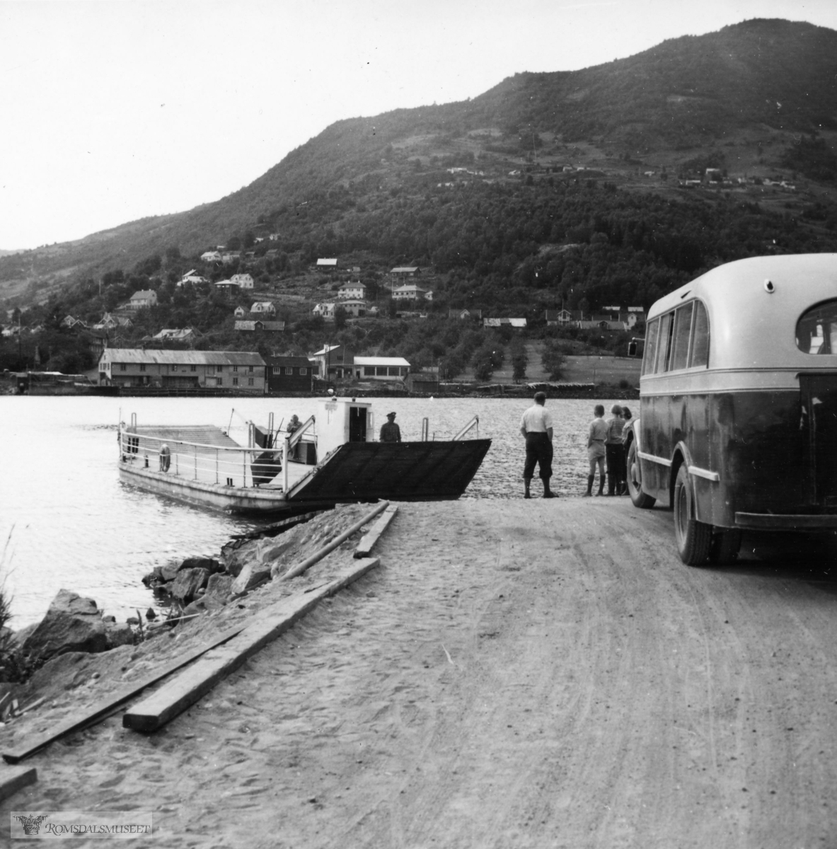 Sogndal, med Loftesnesferja som traffikerte sundet før brua stod ferdig i 1958. Rutebilen er trolig fra Sogn Billag.
