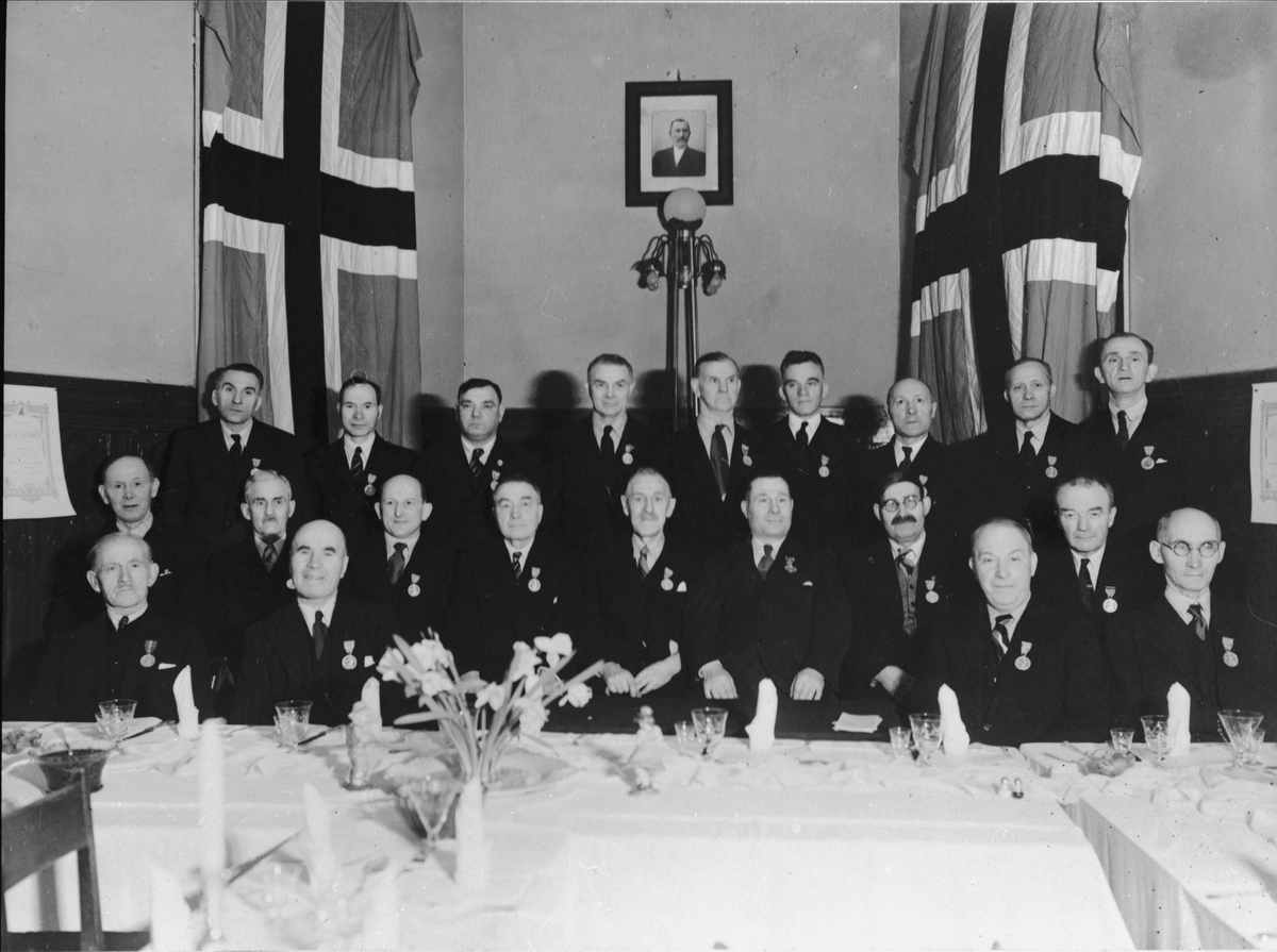 Gruppeportrett av arbeidere ved Kaarbøverkstedet, tatt i forbindelse med utdeling av medalje for lang og tro tjeneste.