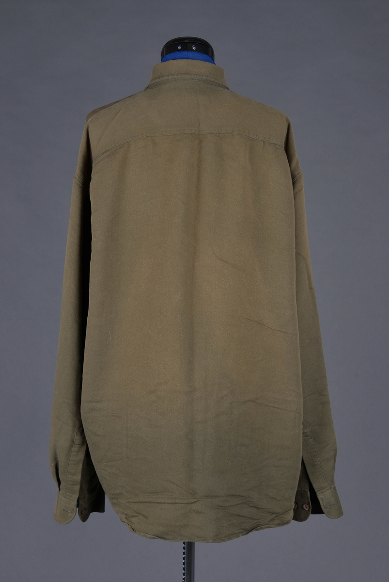 Skjorte med snipper, knappestolpe foran og brystlommer med klaff.
Produsert av Dressmann, som startet opp i 1965, så har ikke vært en del av Lingeuniformen. Antatt å ha erstattet skjorter som ble brukt under krigen