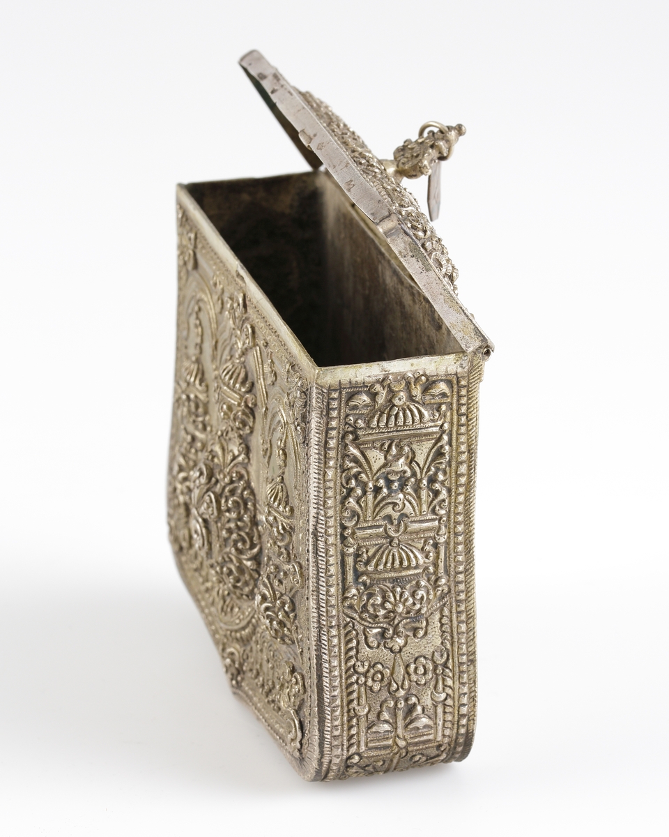 Väska av arbetat silver. Enligt uppgift persiskt arbete (nuvarande Iran). 

Inskrivet i huvudkatalog 1909.
Funktion: Dräktväska