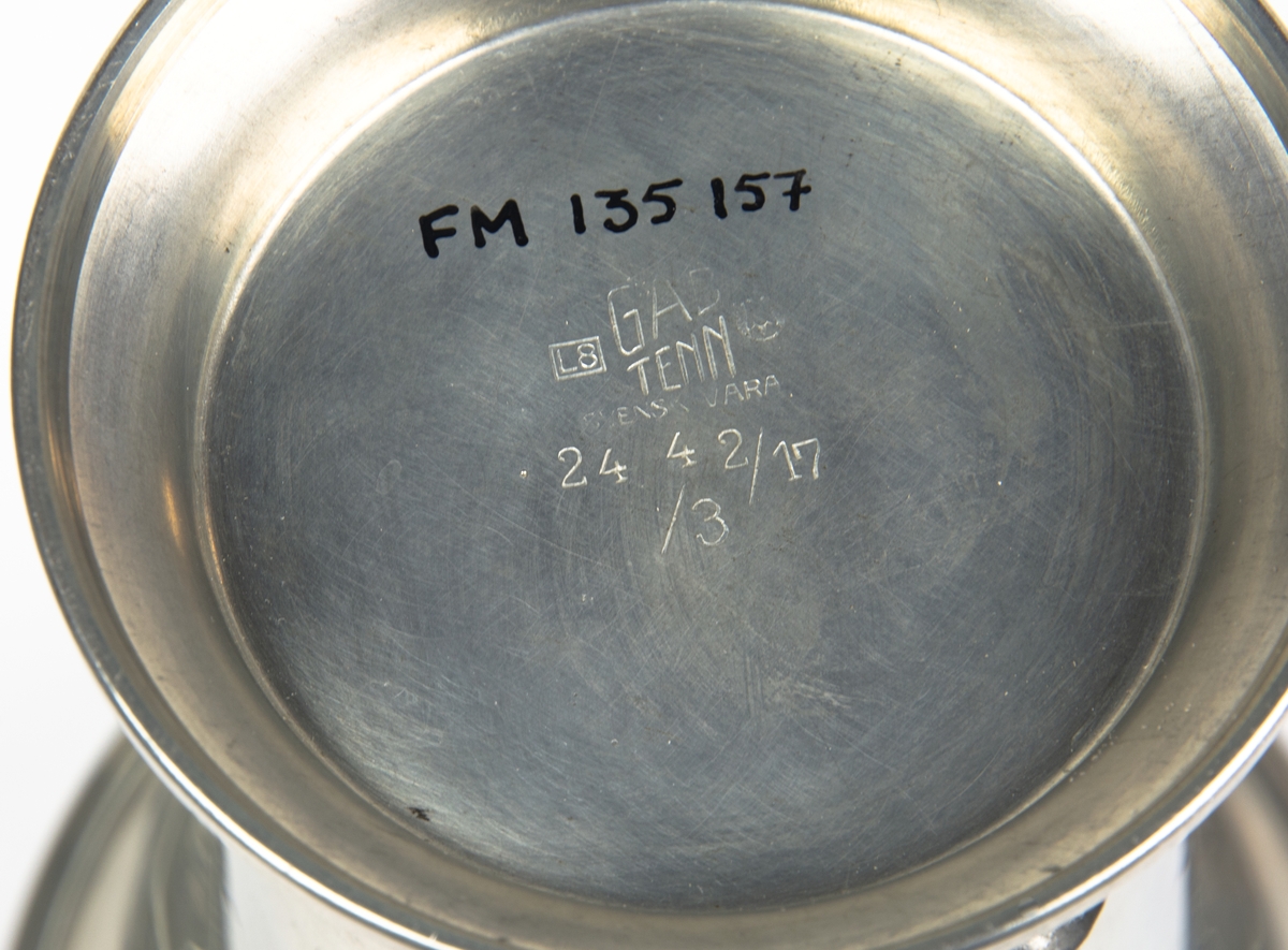 Pokal på tre kulfötter stående på sockel av tenn. Graverad med texten: "D.M. 3x10 km. Finspong 1938" 
Botten märkt: "L8, GAS, TENN, SVENSK VARA 24, 4, 2/17, 13".