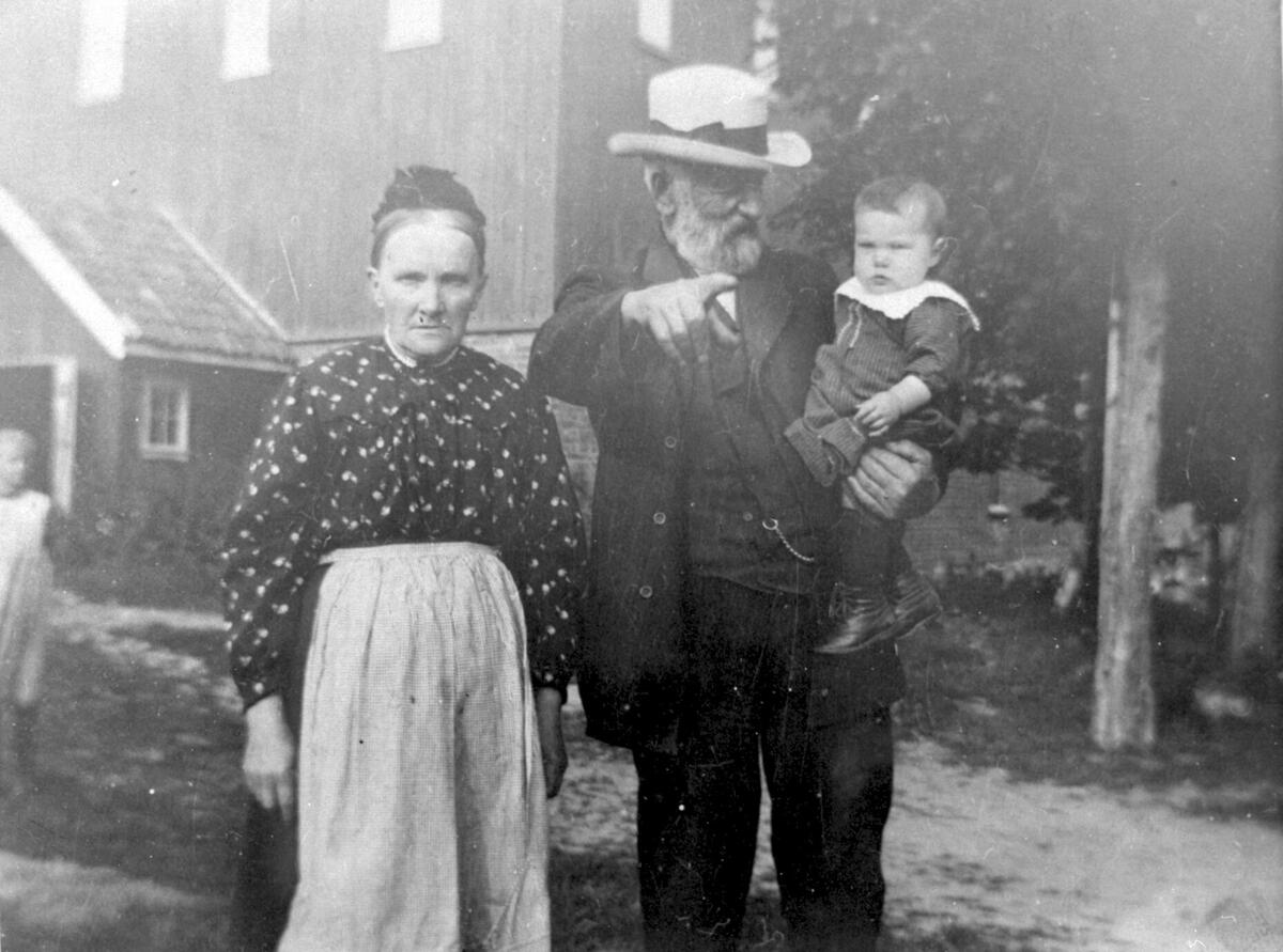 Bestemor og bestefar med barnebarn på armen
