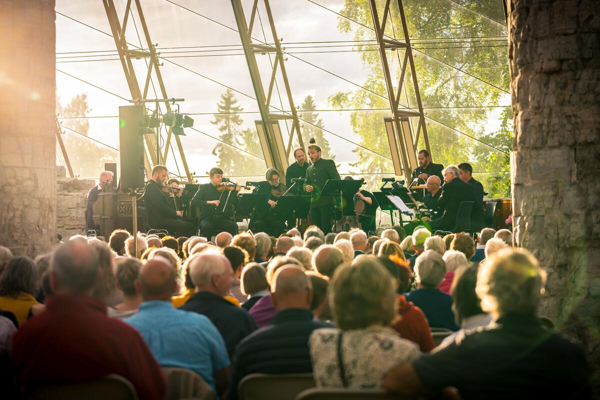 Bilde fra konsert i Hamardomen, Domkirkeodden. Bilde av solist med orkester foran publikum.