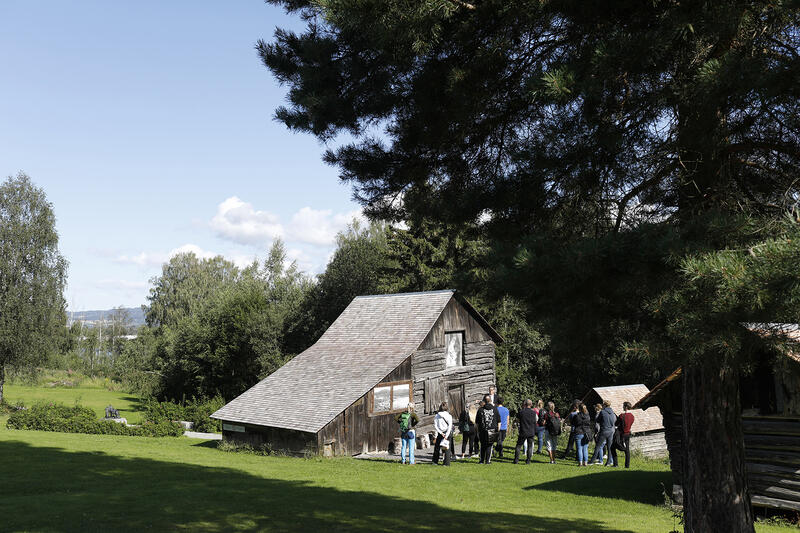 A group of people is standing in front of one of the buildings outside the museum.